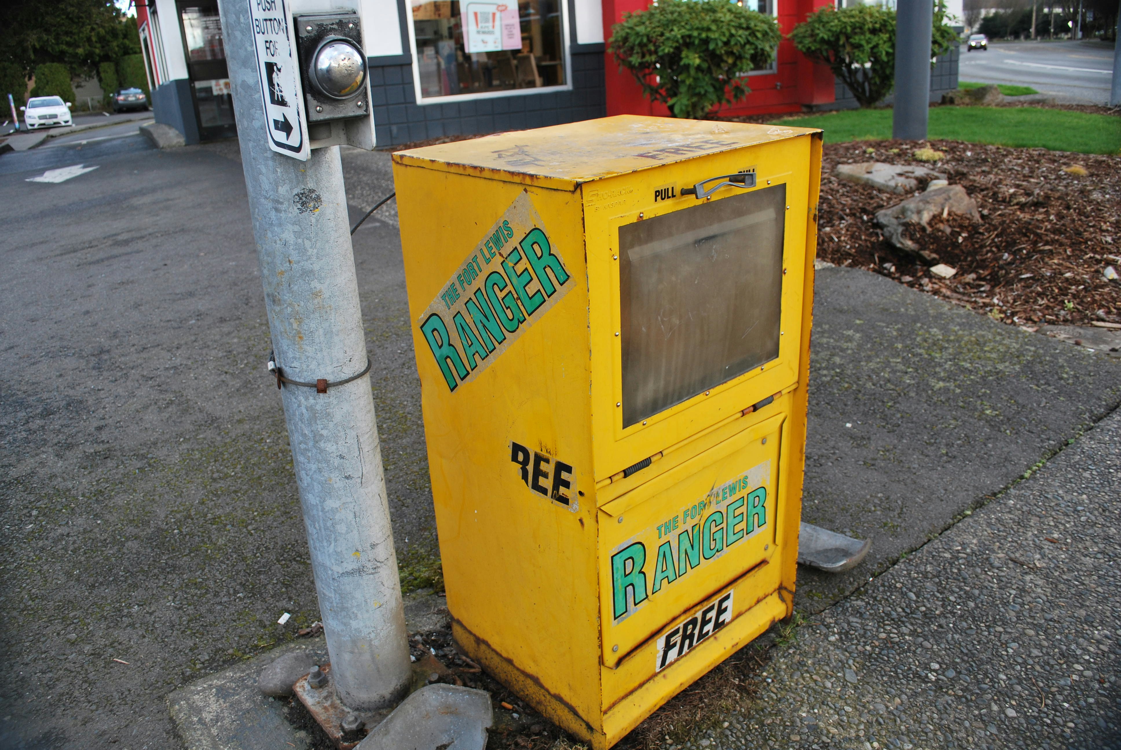 a yellow machine sitting on the side of a road
