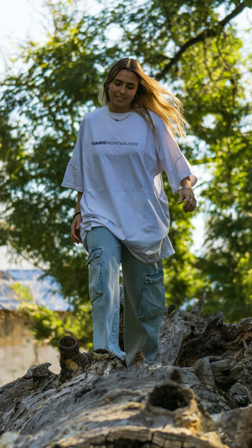 a woman walking on a log in the woods