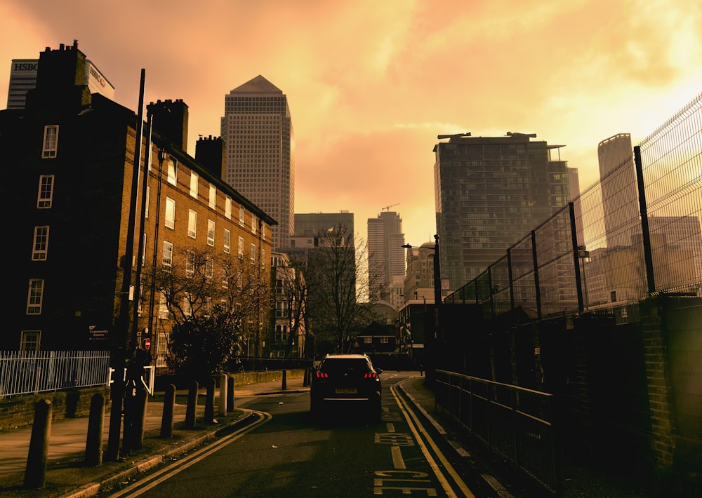 a car driving down a street next to tall buildings