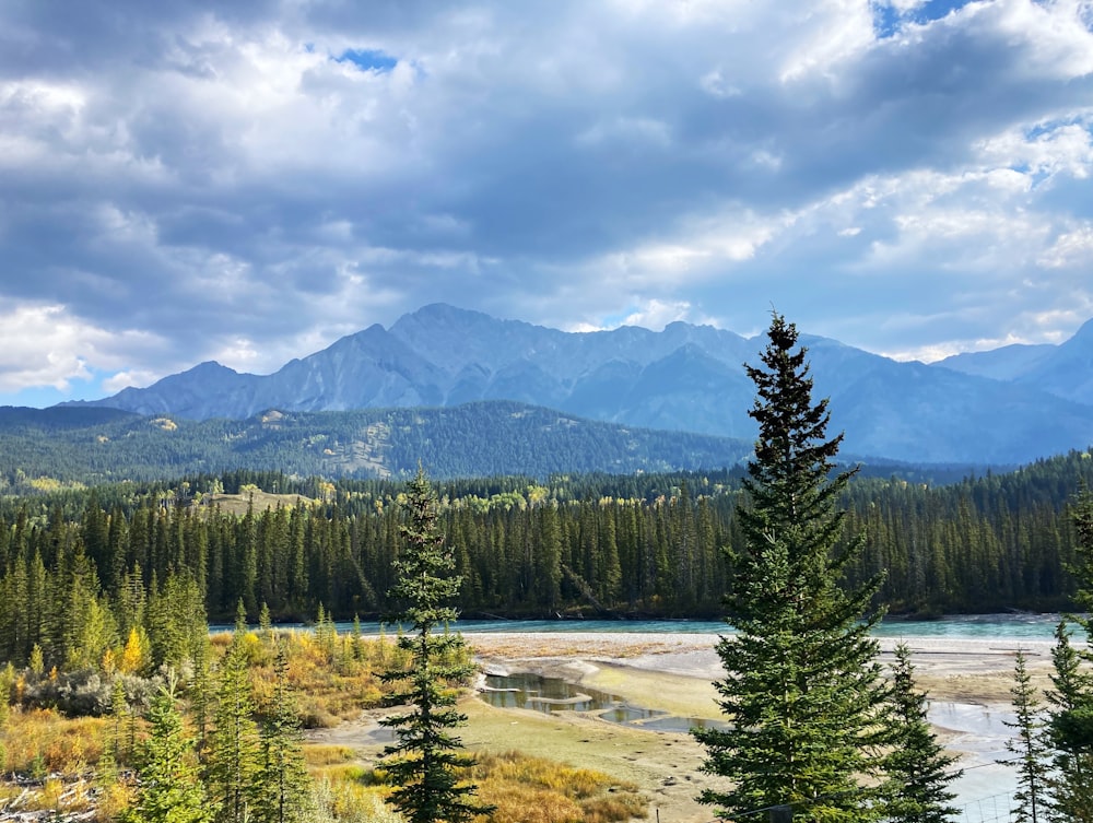 a scenic view of a mountain range with a river in the foreground