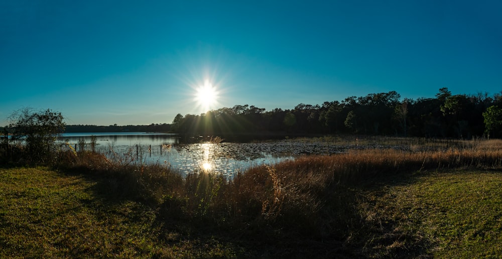 the sun shines brightly over a small lake