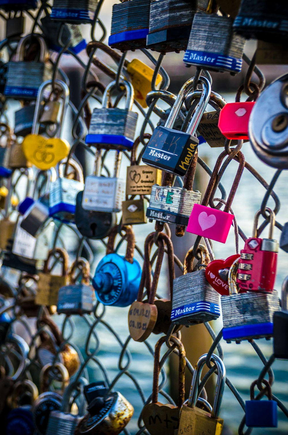 a bunch of padlocks attached to a fence