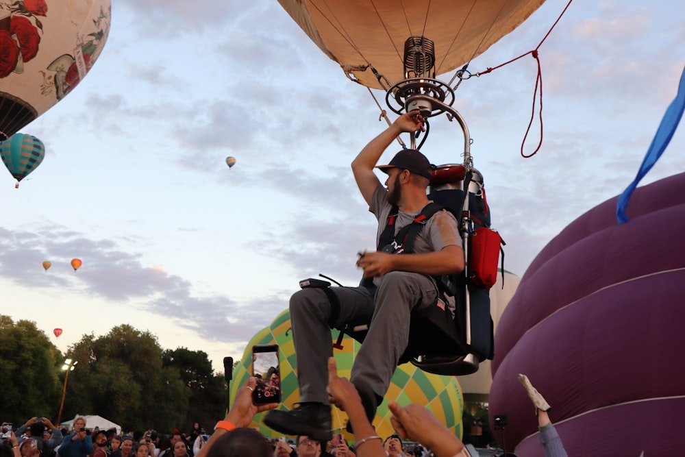 a man sitting on top of a hot air balloon