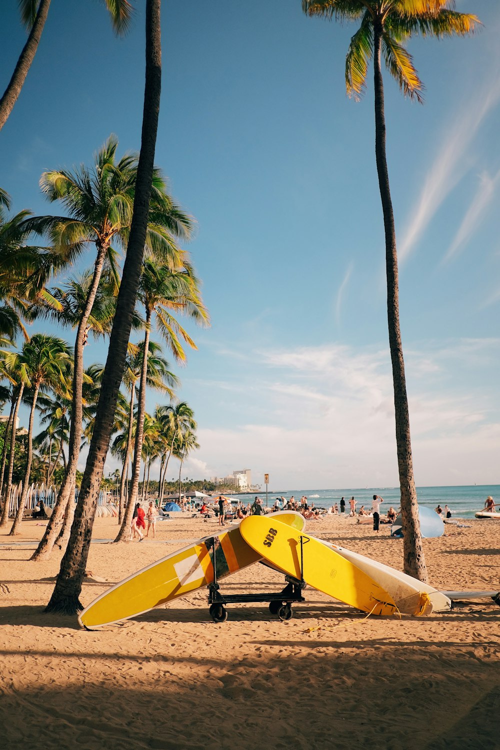 a yellow surfboard sitting on top of a sandy beach