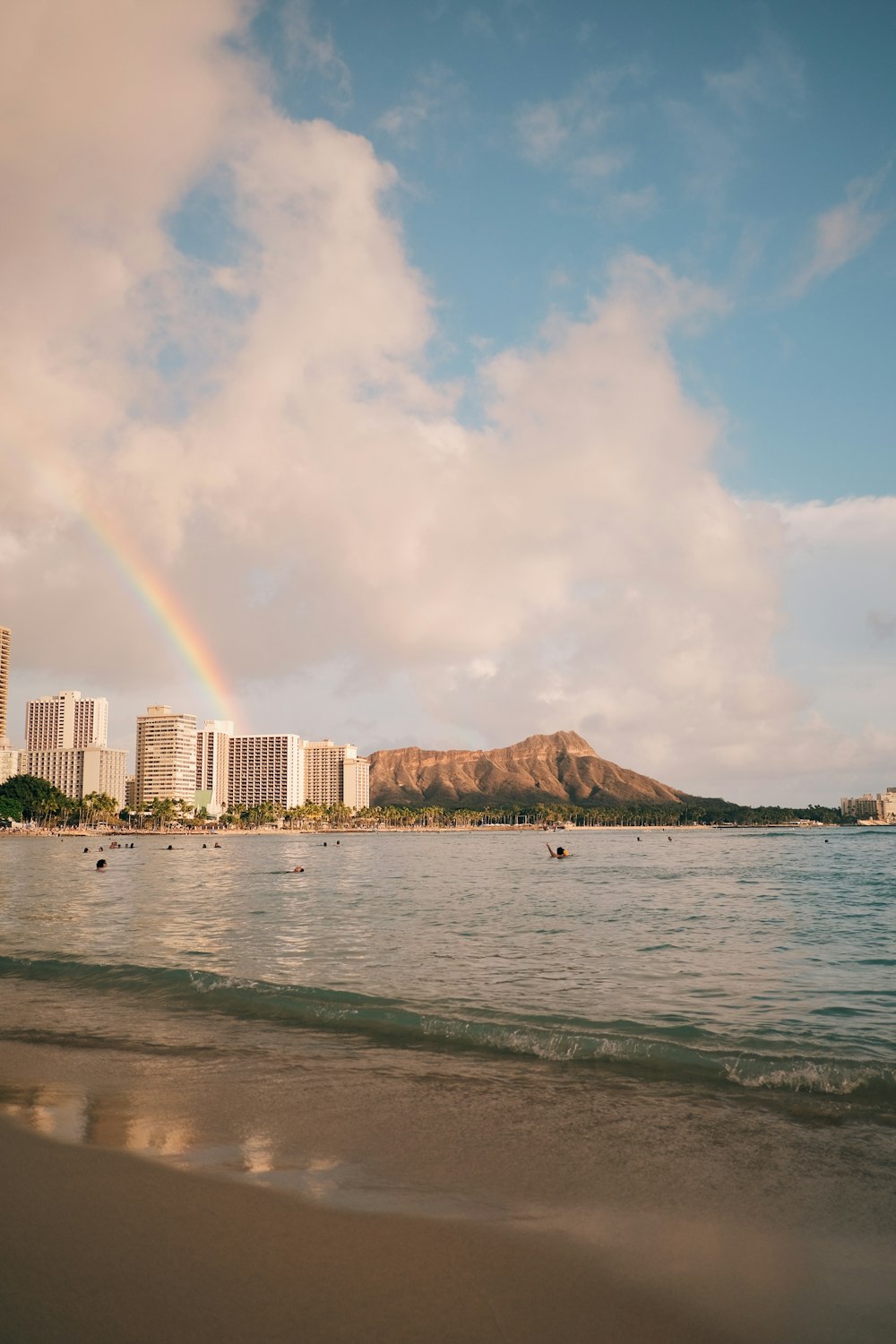 a rainbow in the sky over a beach