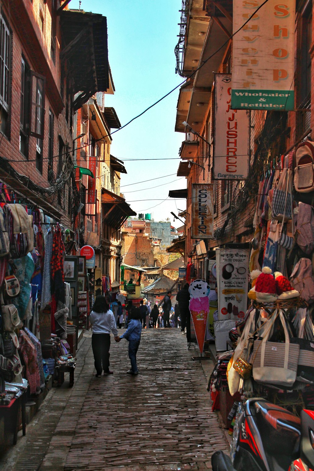 a group of people walking down a street next to buildings