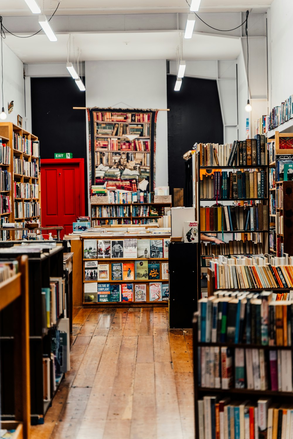 a room filled with lots of books and a red door