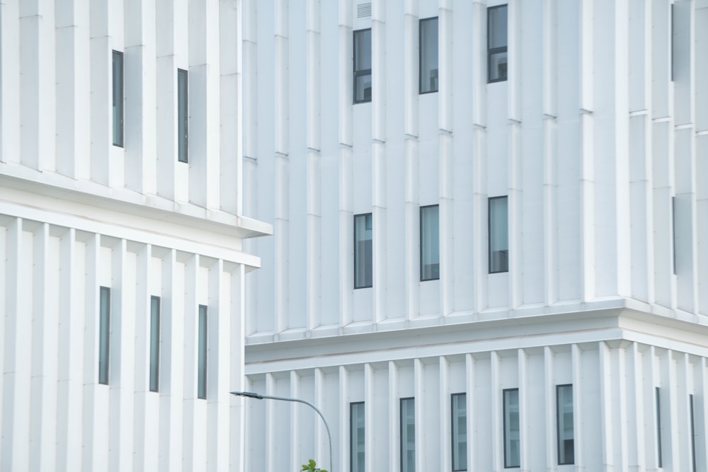 a tall white building sitting next to a street light