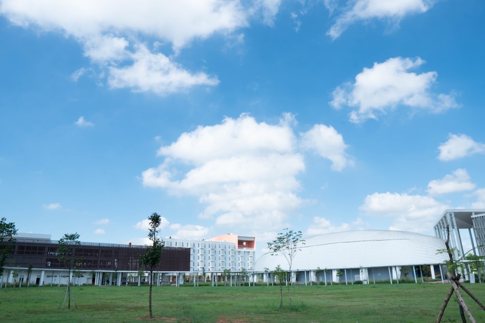 a large white building sitting on top of a lush green field