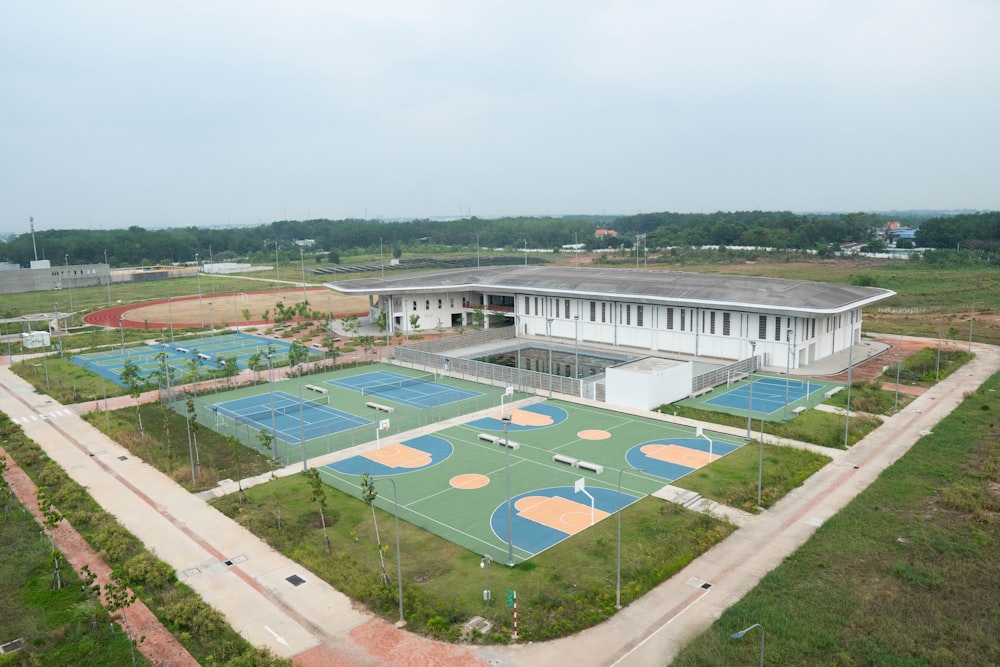 an aerial view of a tennis court with a building in the background