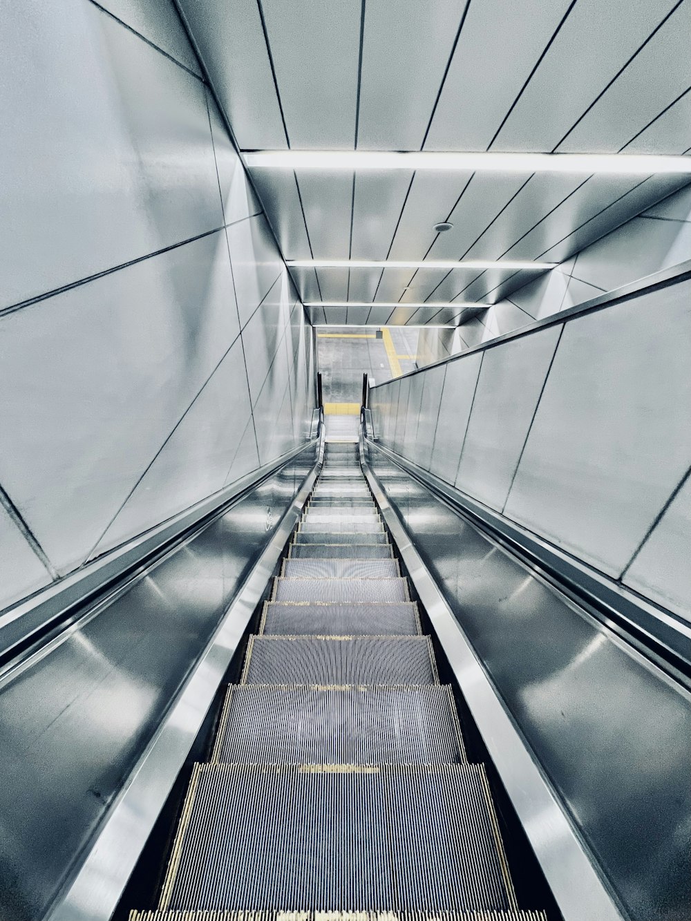 an escalator in a subway station with a person on the escalator