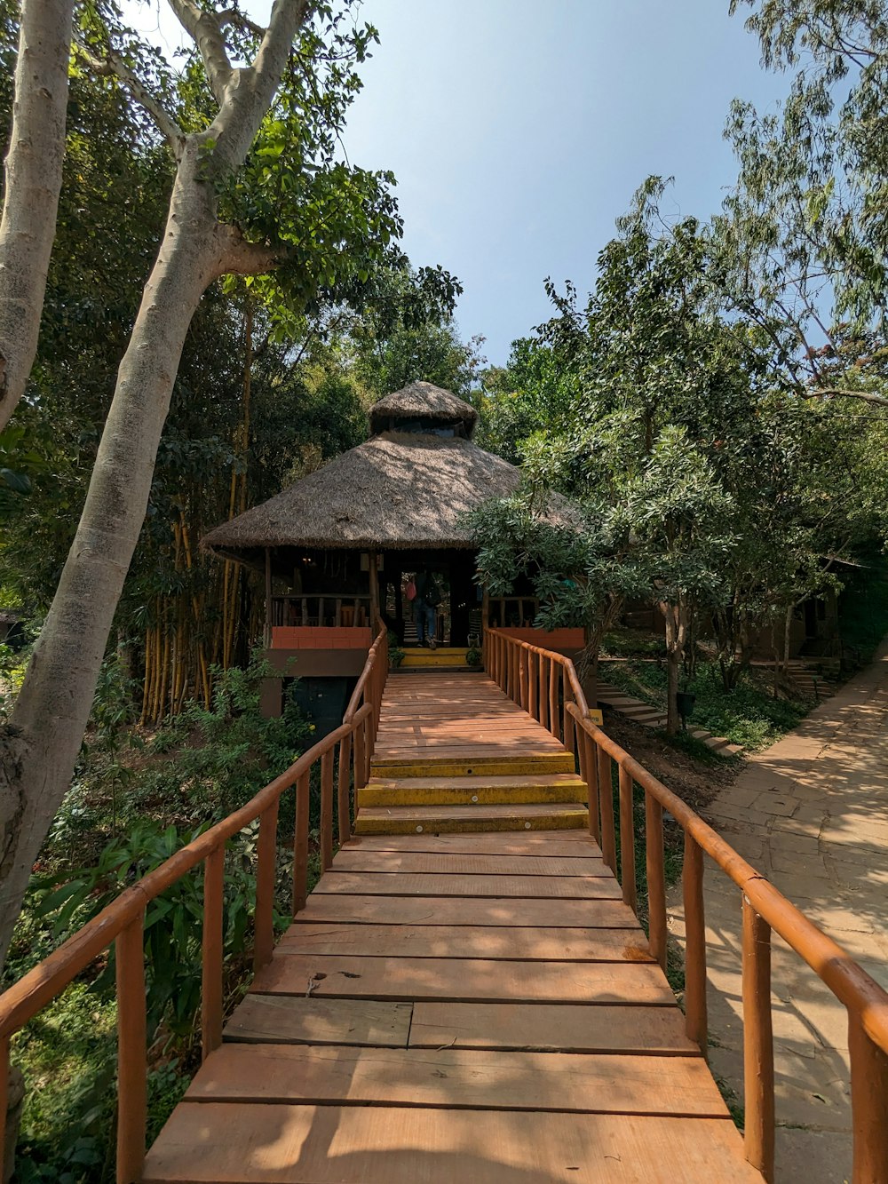 a wooden walkway with a gazebo in the background