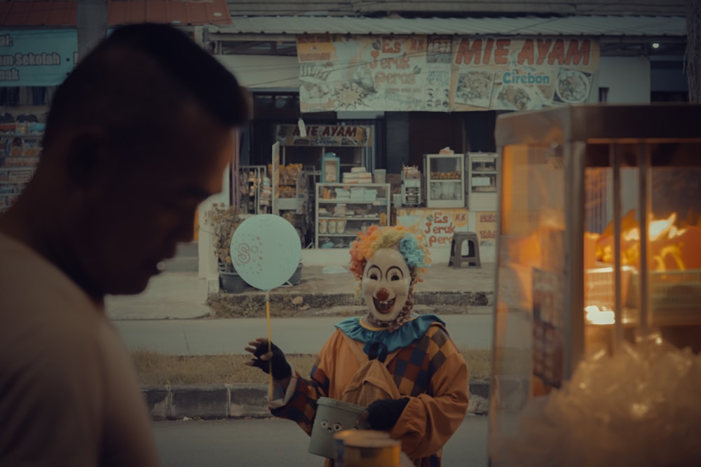 a man standing next to a creepy clown