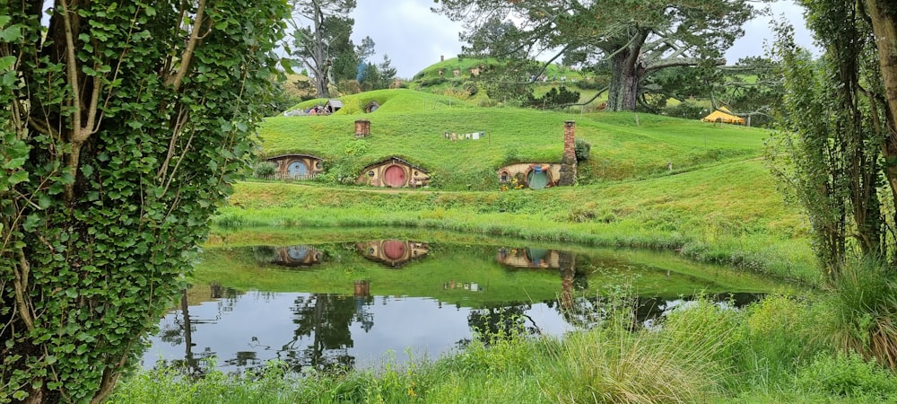 a green hobbot with a pond in the middle of it