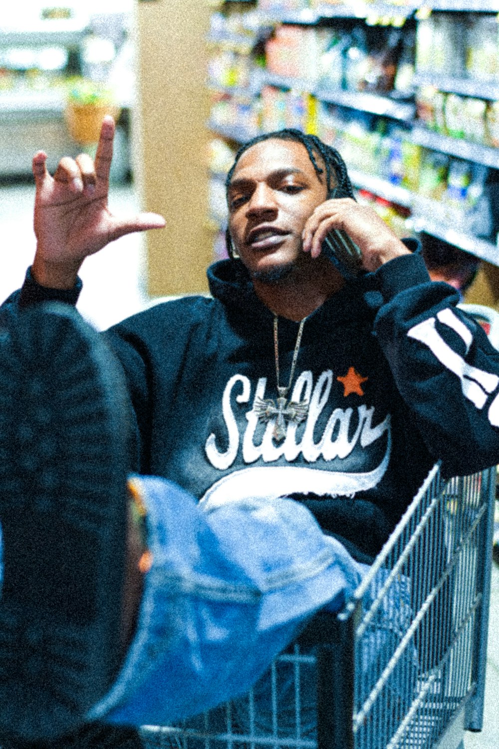 a man sitting in a shopping cart talking on a cell phone