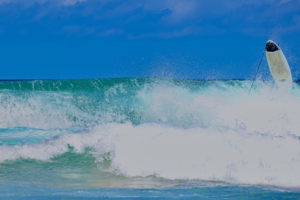 a man riding a wave on top of a surfboard