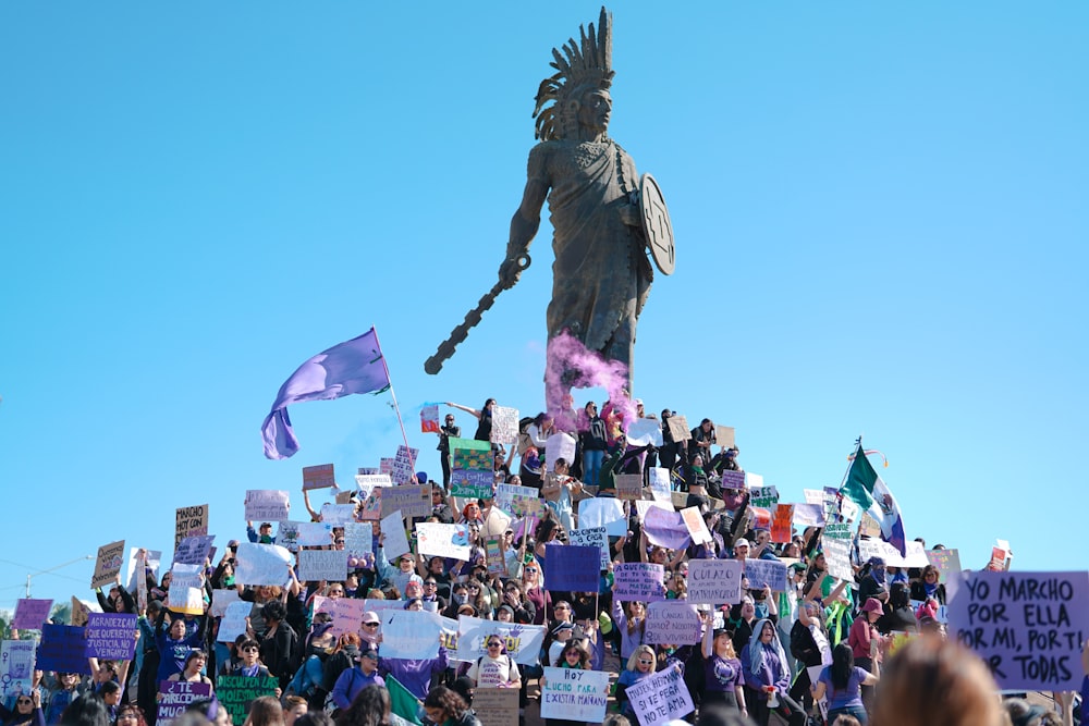 a crowd of people standing around a statue