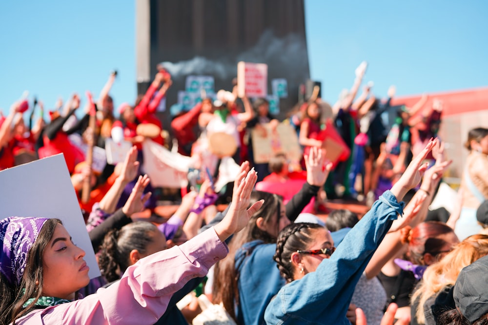 a crowd of people with their hands in the air