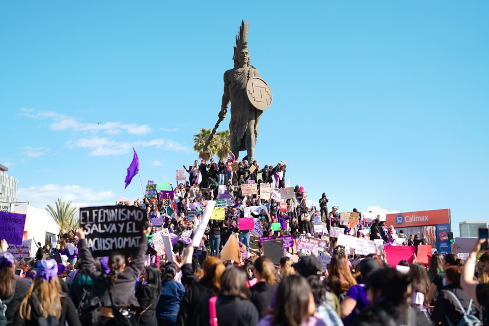 a crowd of people standing around a statue