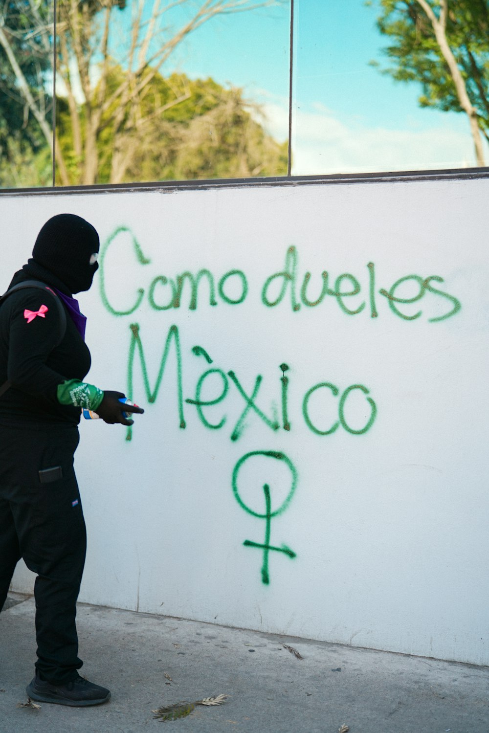 a man in a black hoodie writing on a wall