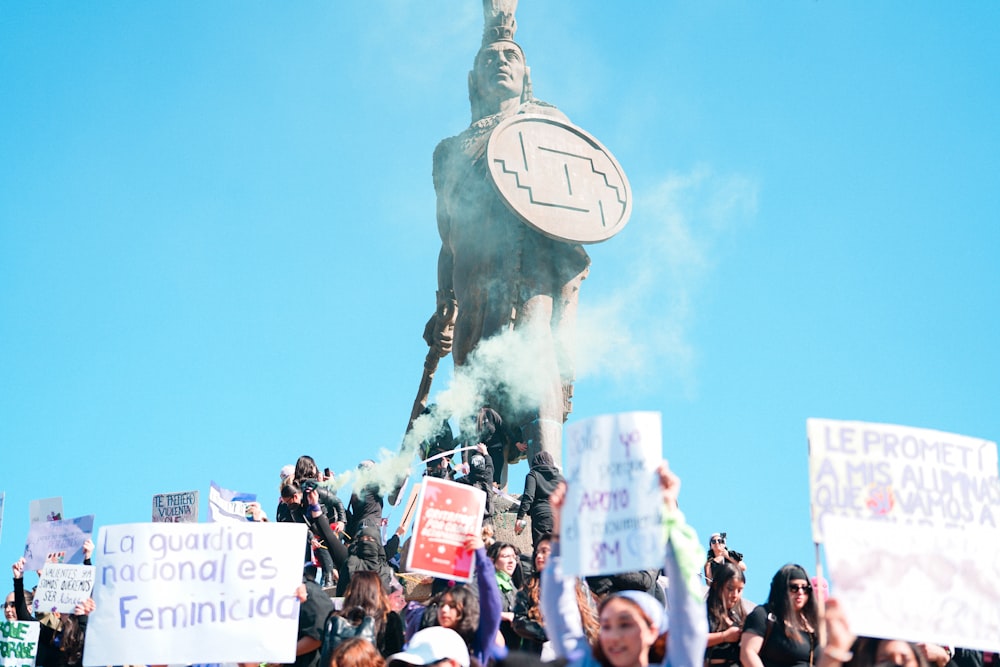 a crowd of people standing around a statue