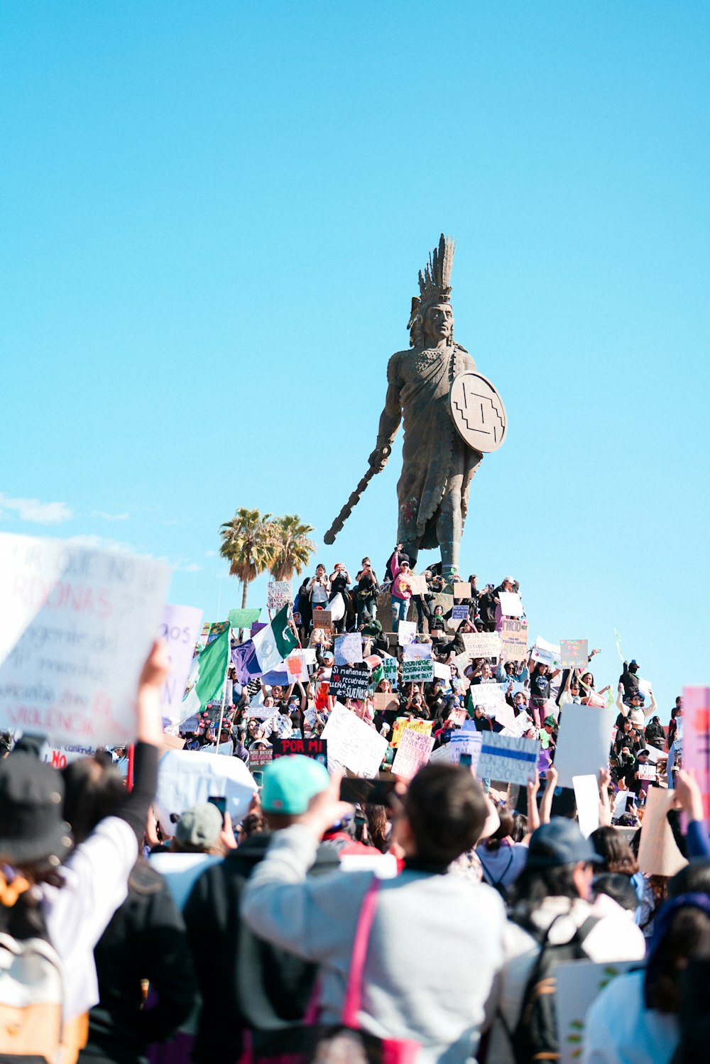a crowd of people standing around a large statue