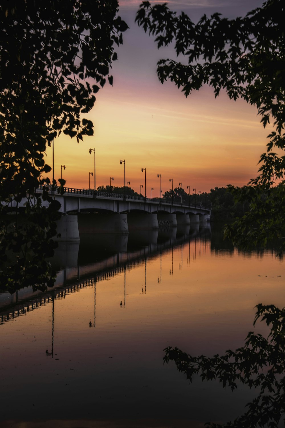 un ponte su uno specchio d'acqua al tramonto