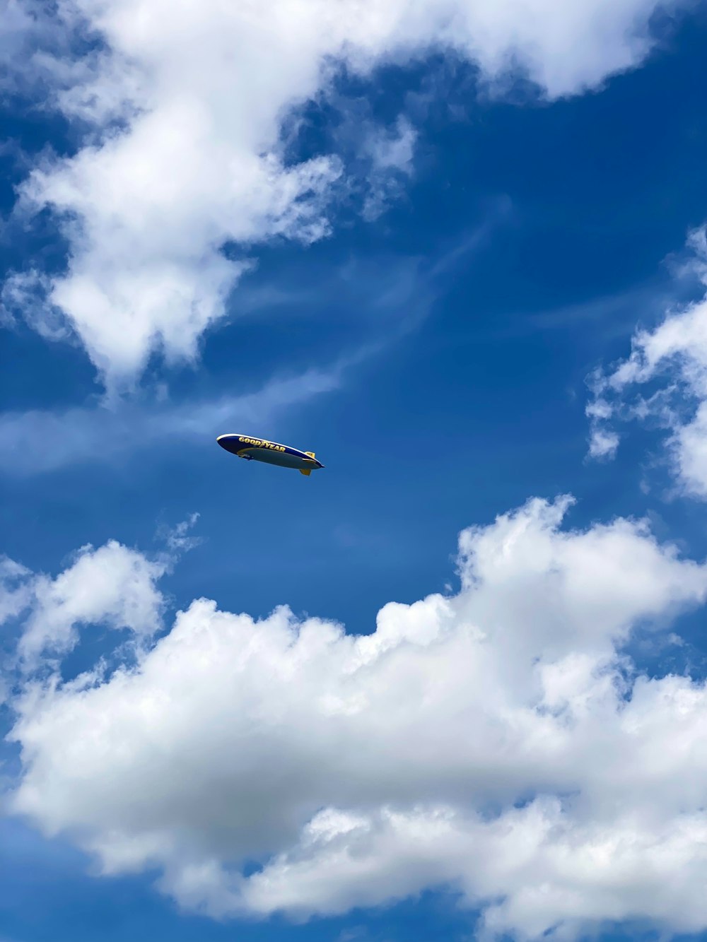 an airplane flying through a cloudy blue sky