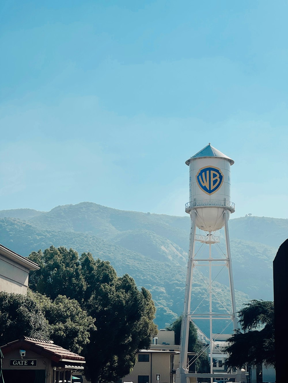 a water tower on a street with mountains in the background