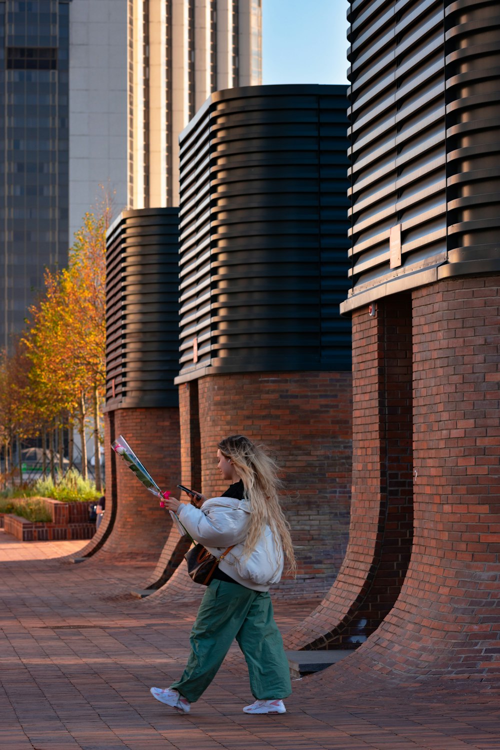 a woman walking down a street holding a baseball bat