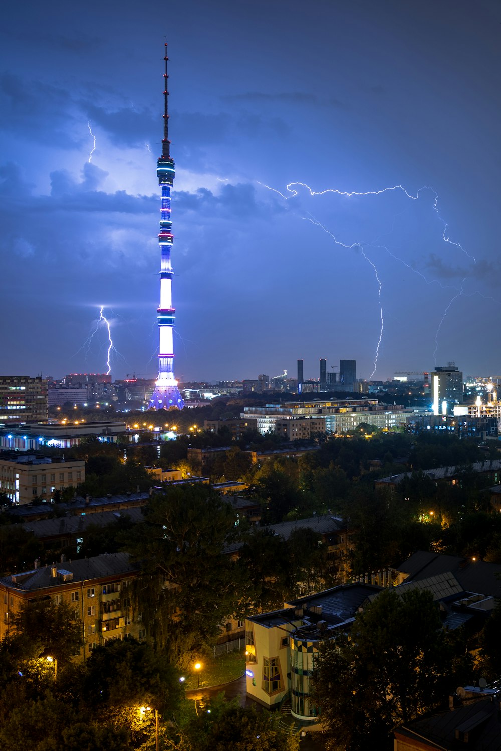 a lightning bolt strikes over a city at night