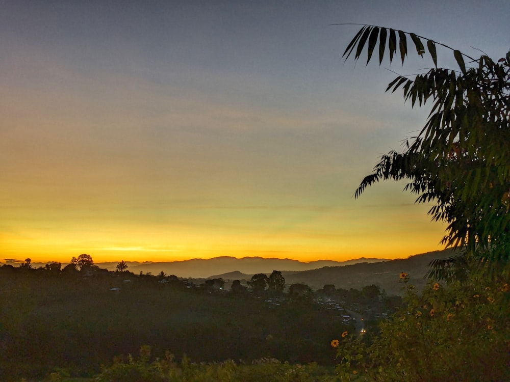 the sun is setting over the mountains in the distance