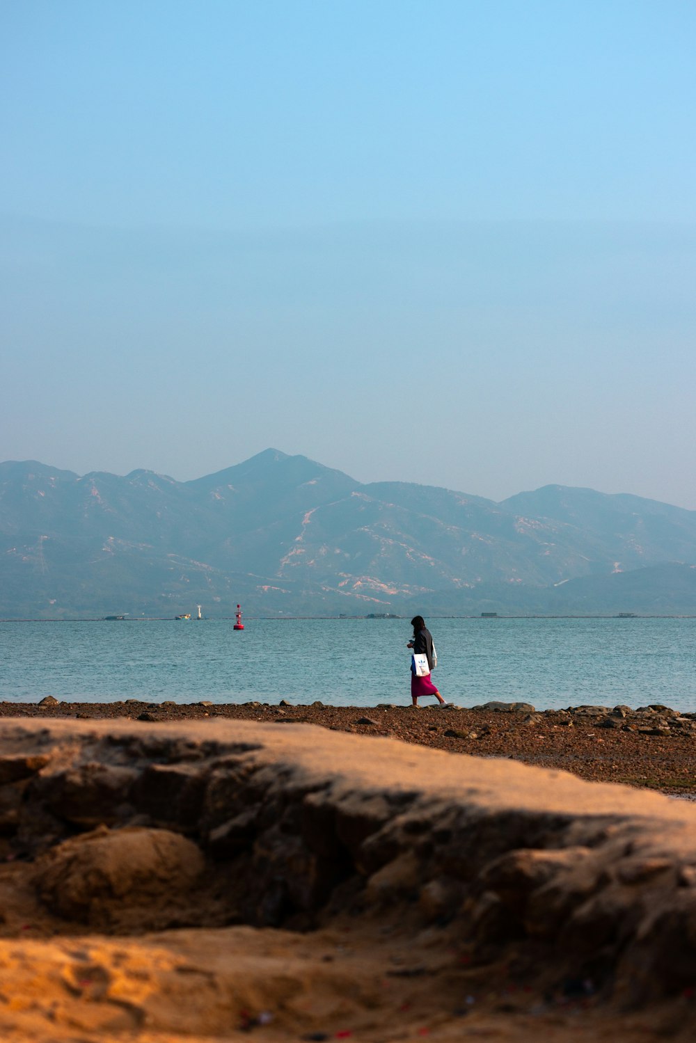 a person standing on a beach next to the ocean