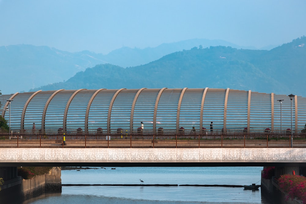 a bridge over a body of water with mountains in the background