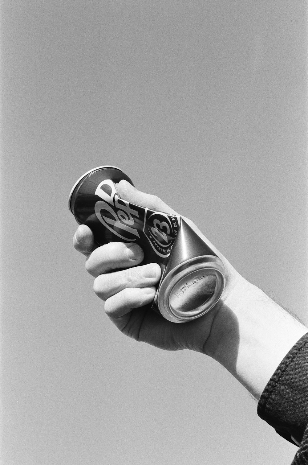 a person holding a can of soda in their hand
