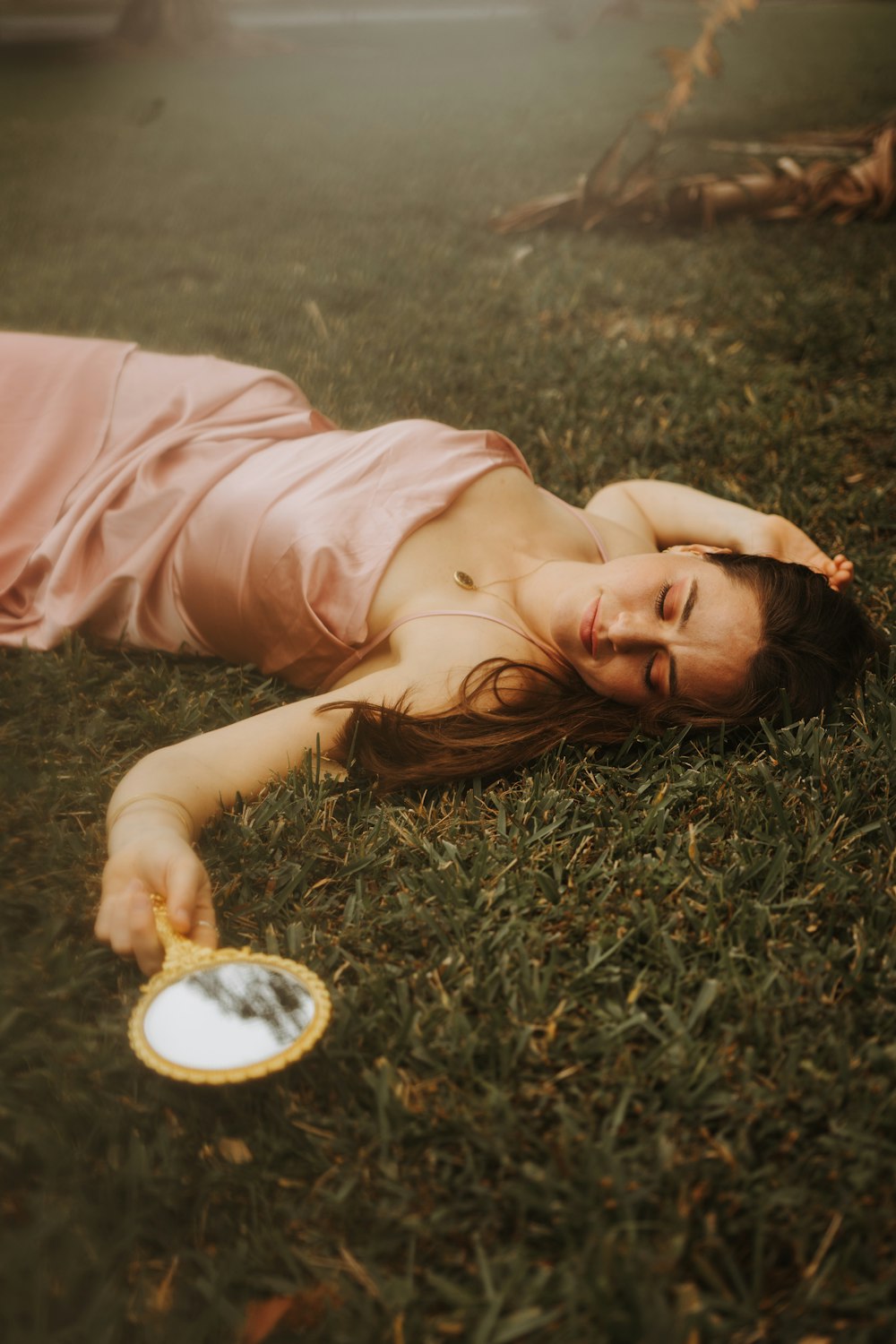 a woman laying in the grass with a frisbee
