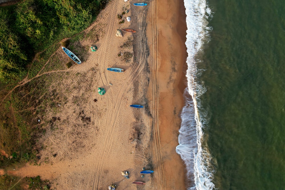 an aerial view of a beach with several boats