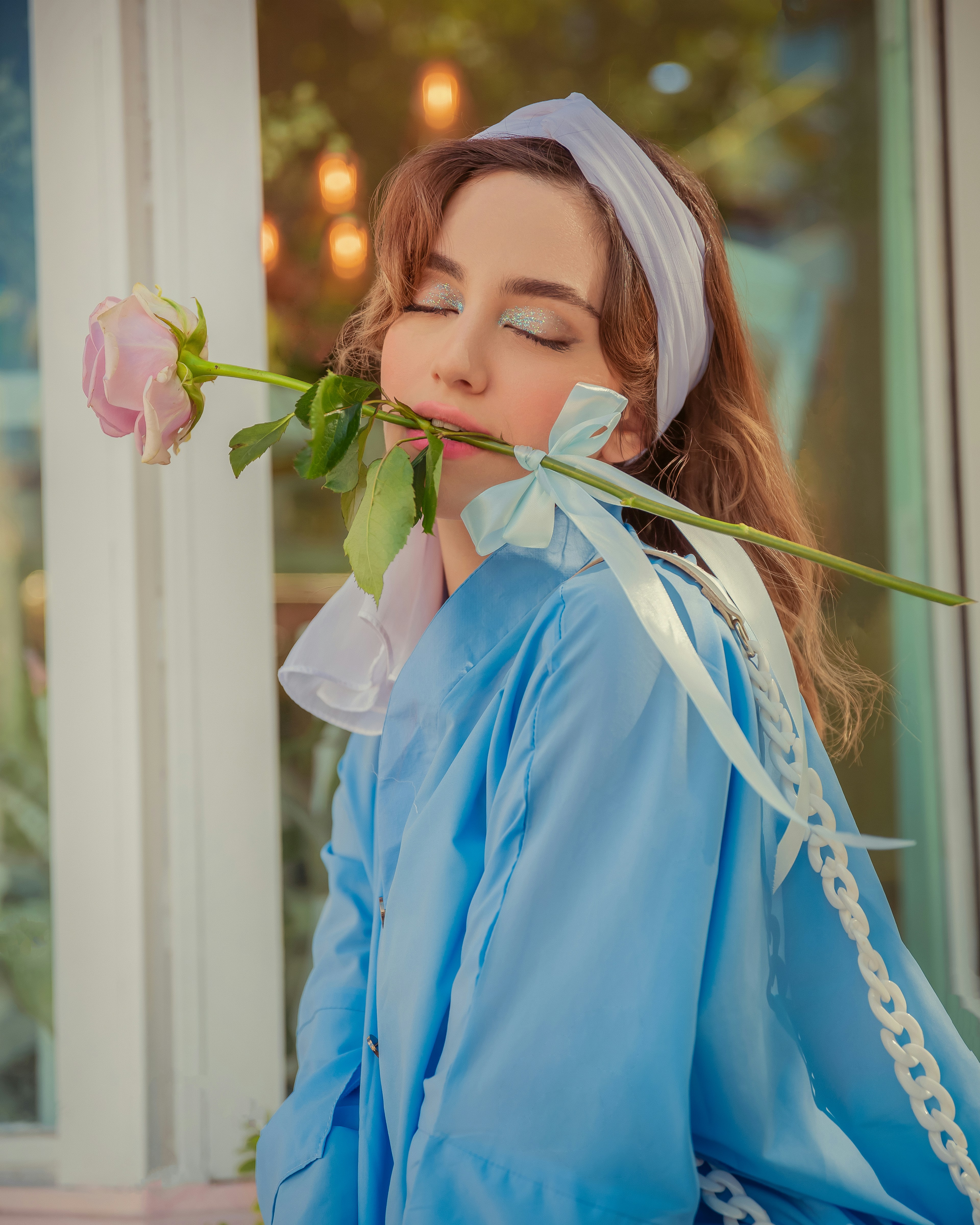 Seorang wanita dengan gaun biru memegang mawar