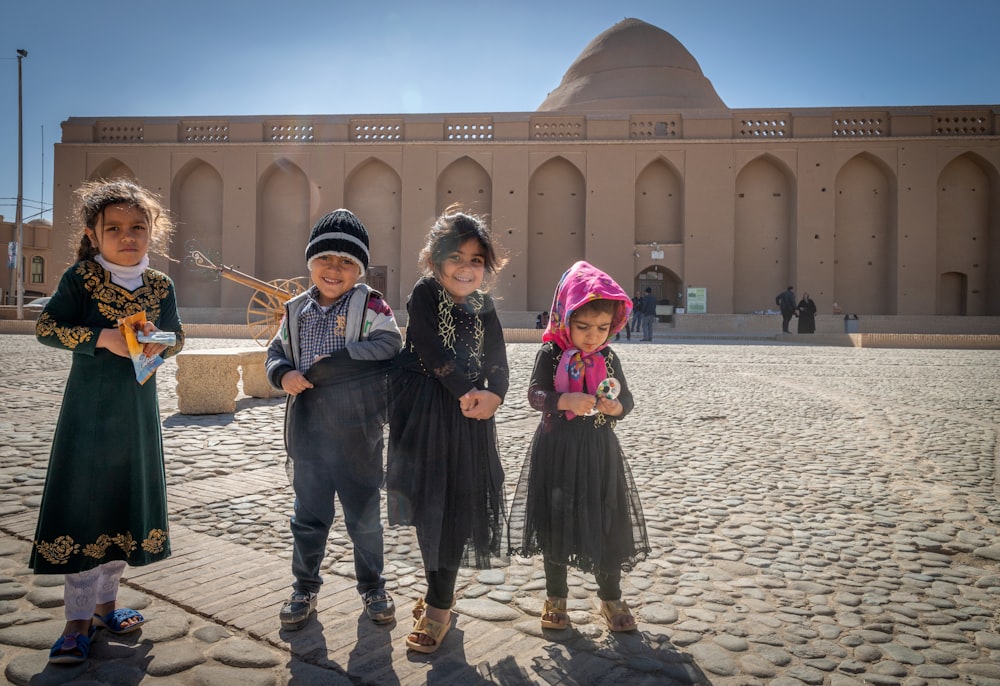 a group of children standing in front of a building