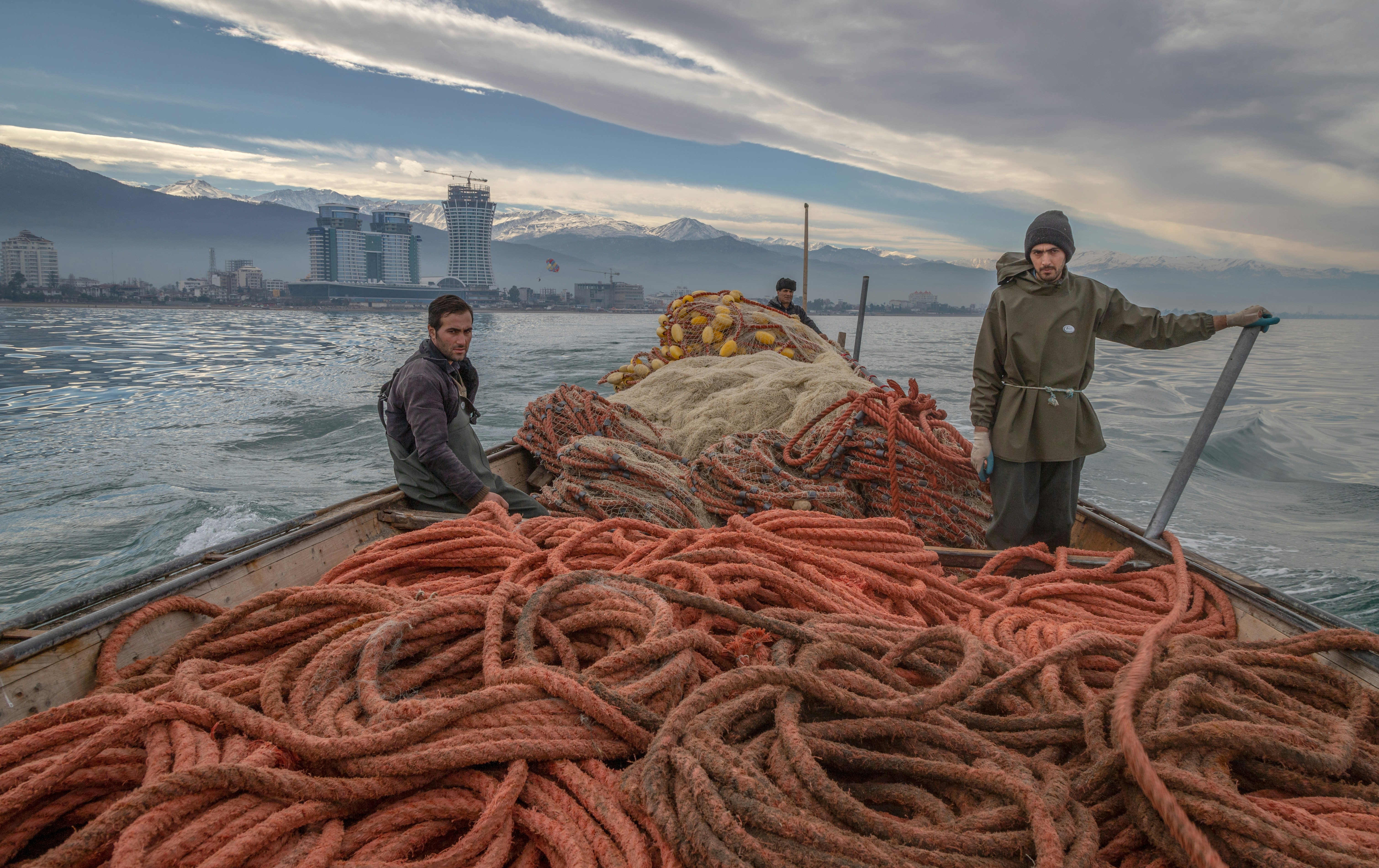 two men standing on a boat in the water
