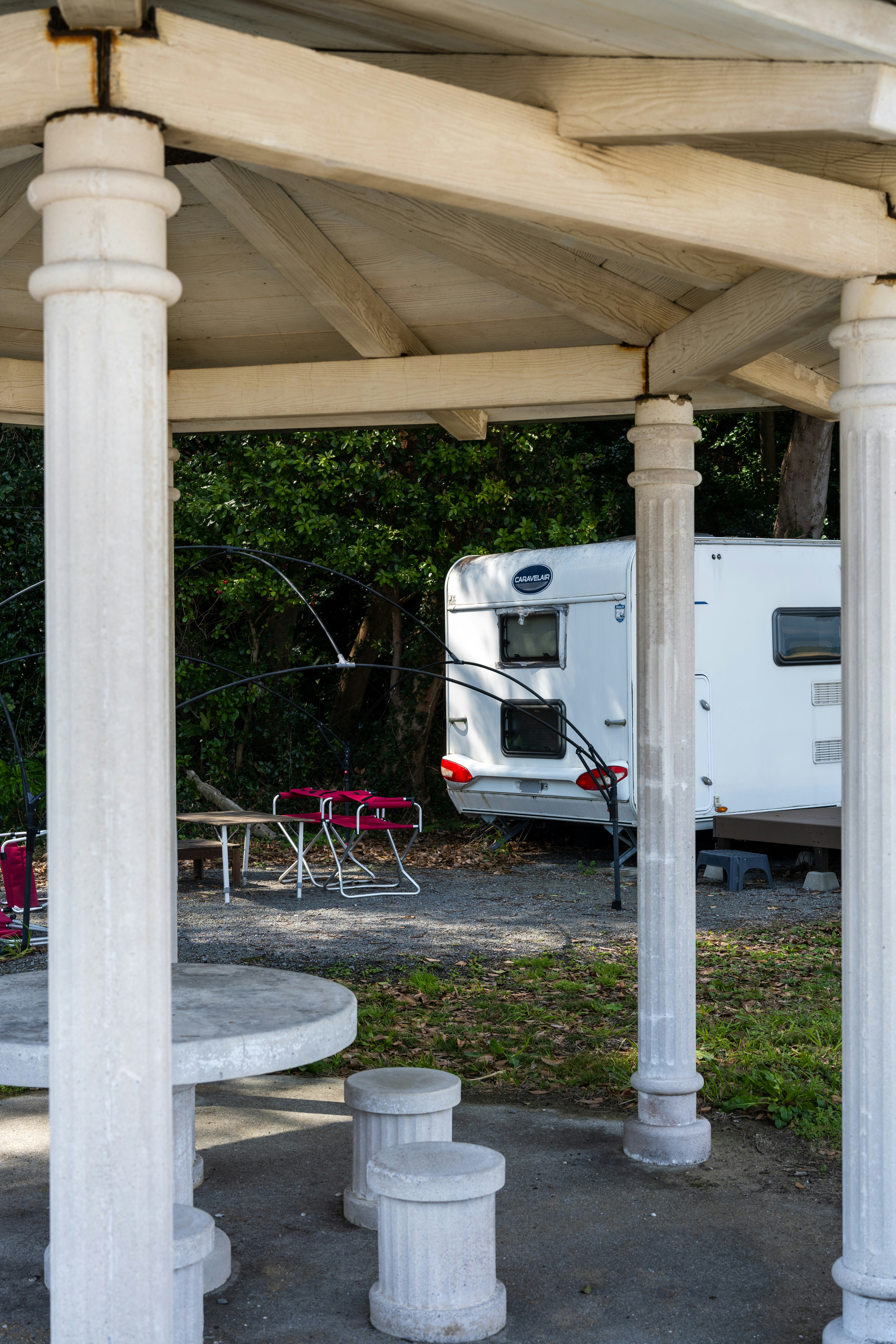 a white rv parked under a wooden structure