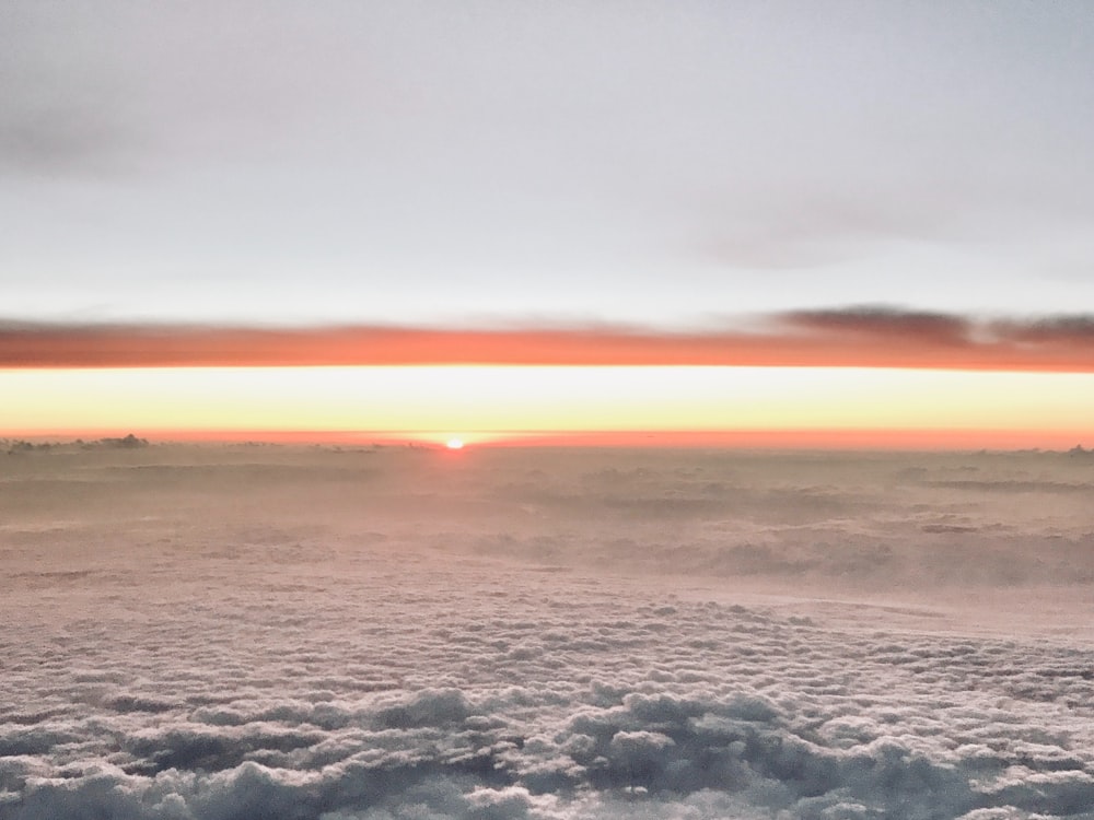 the sun is setting over the clouds in the sky