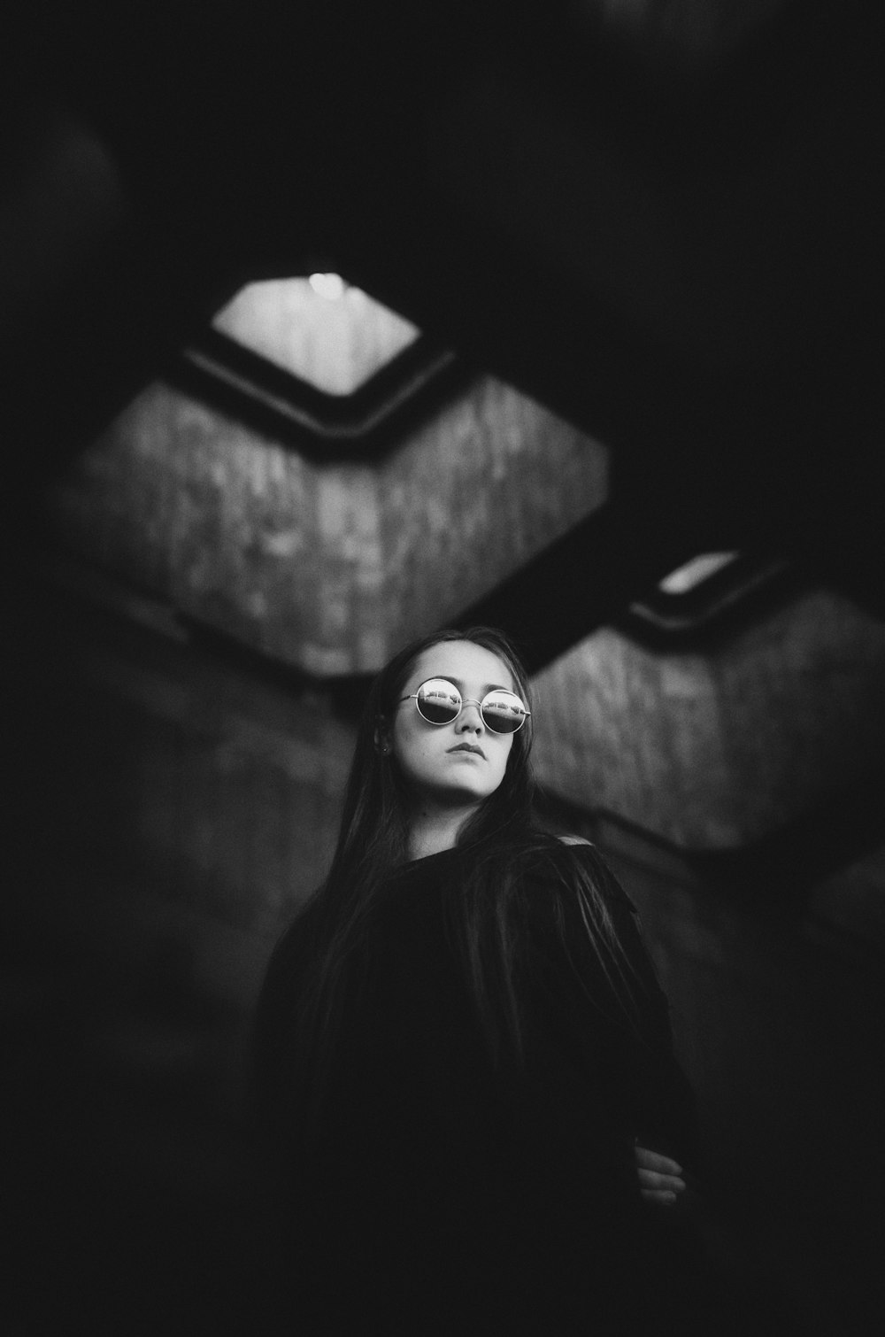 a woman standing in a dark room with her eyes closed