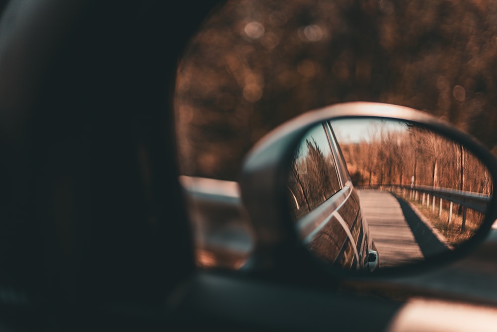 a car's side view mirror reflecting a road