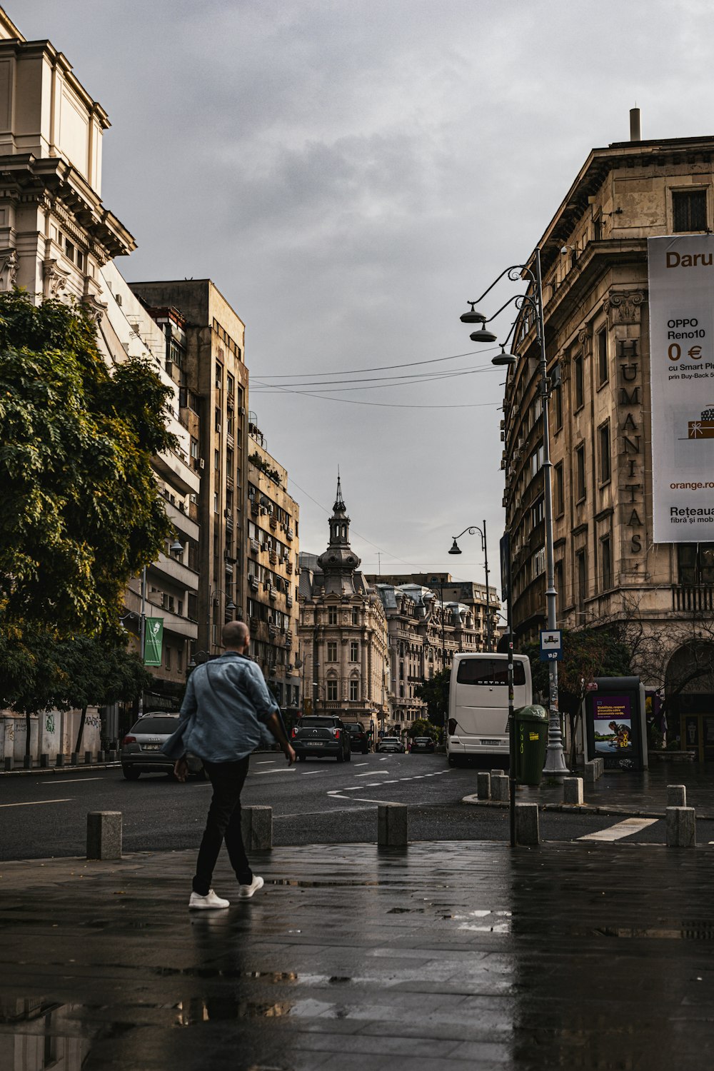 a man walking down a street next to tall buildings