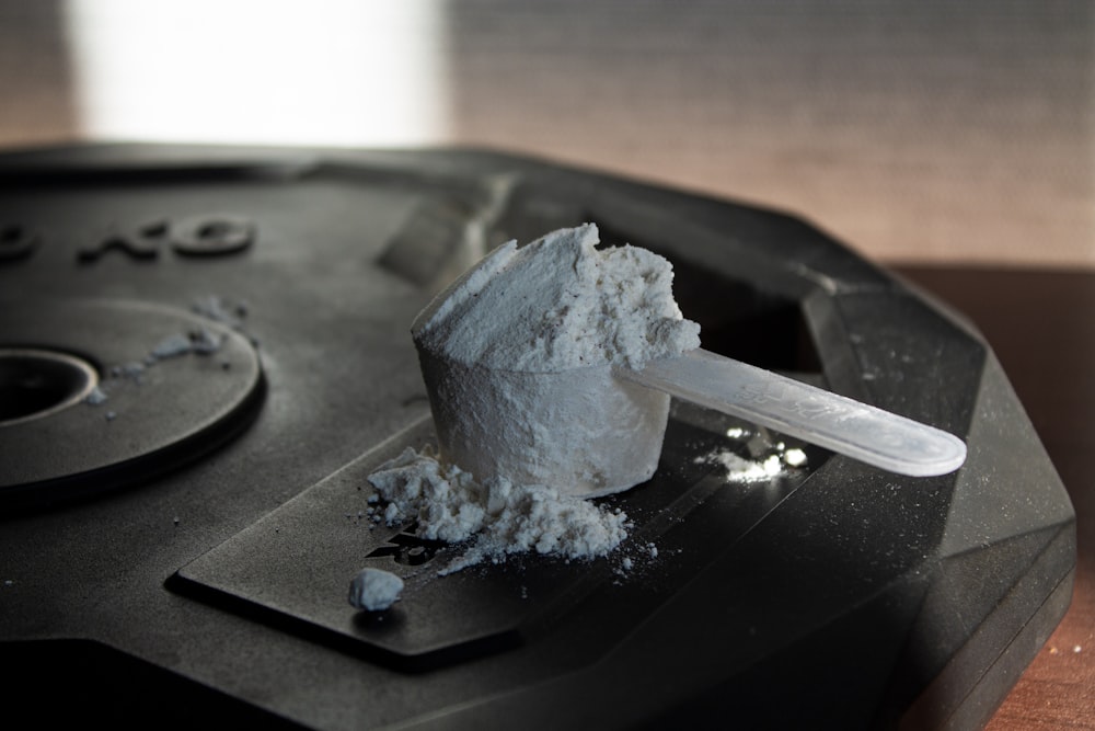 a scoop of white powder sitting on top of a black object