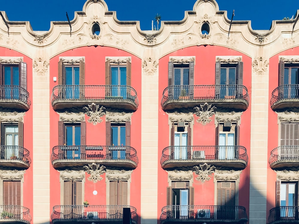 a pink building with balconies and balconies on the balconies