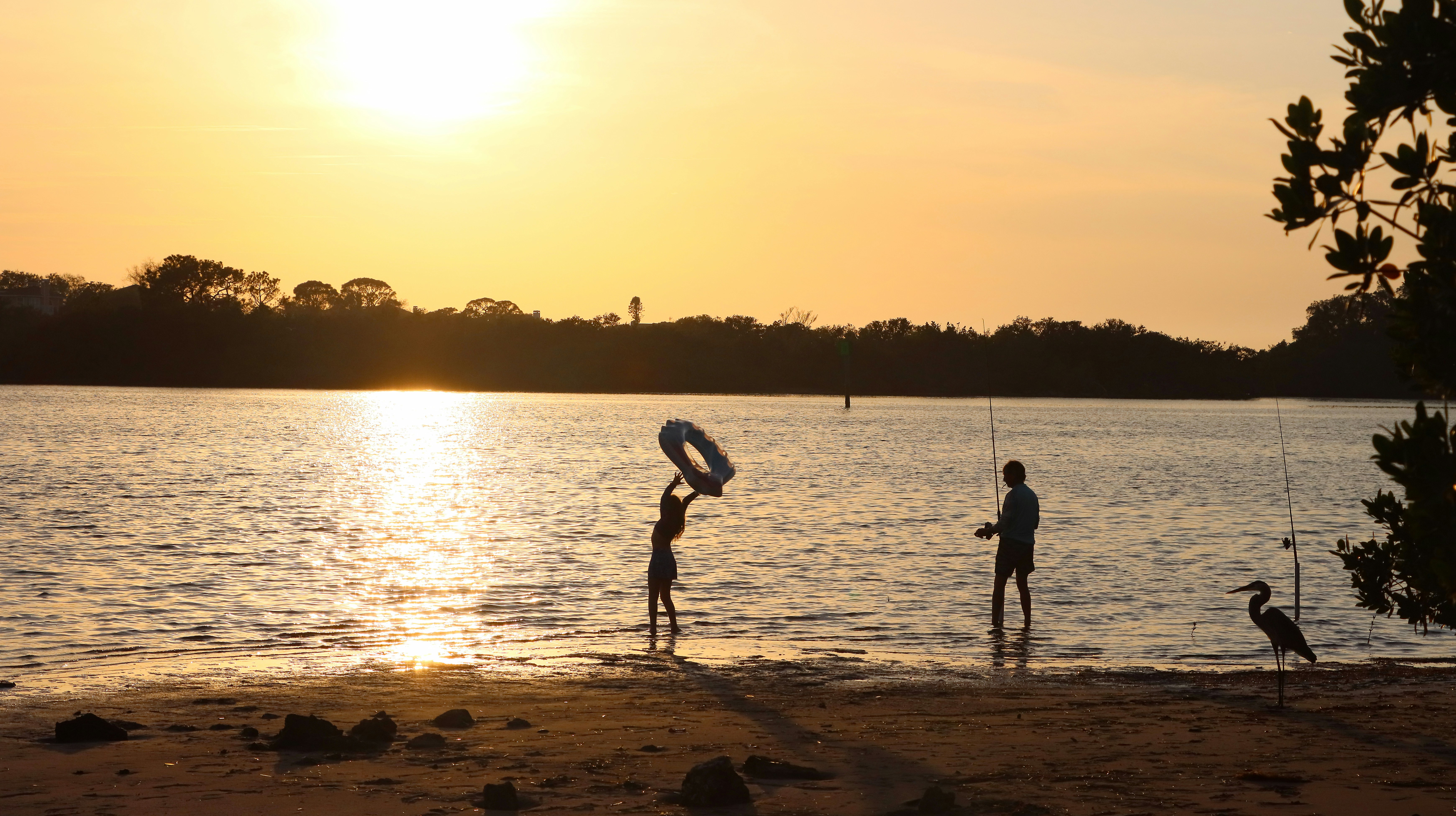 a couple of people standing on top of a beach
