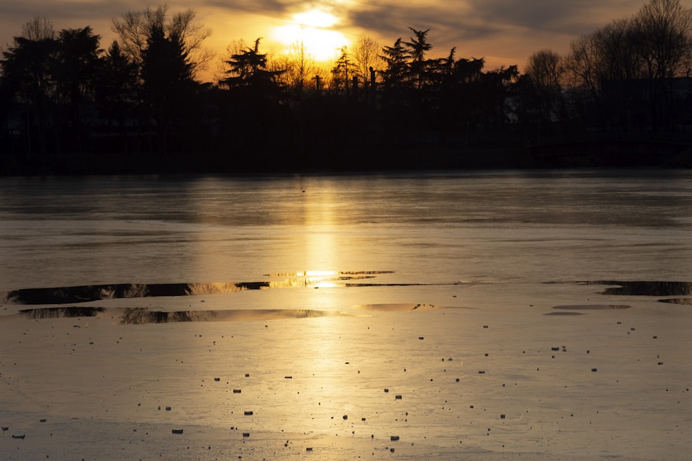 the sun is setting over a body of water