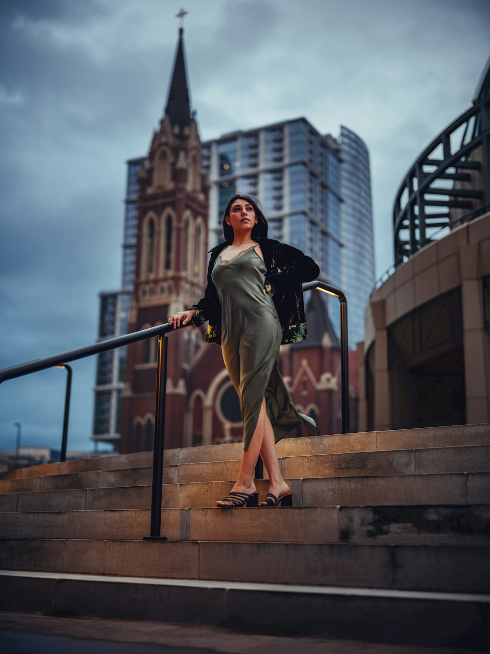 a woman is standing on the steps of a building